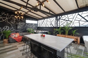 A modern interior with a central bar area, seating, and a geometric wall design. - Room with private bathroom and terrace 3 (Medellín)