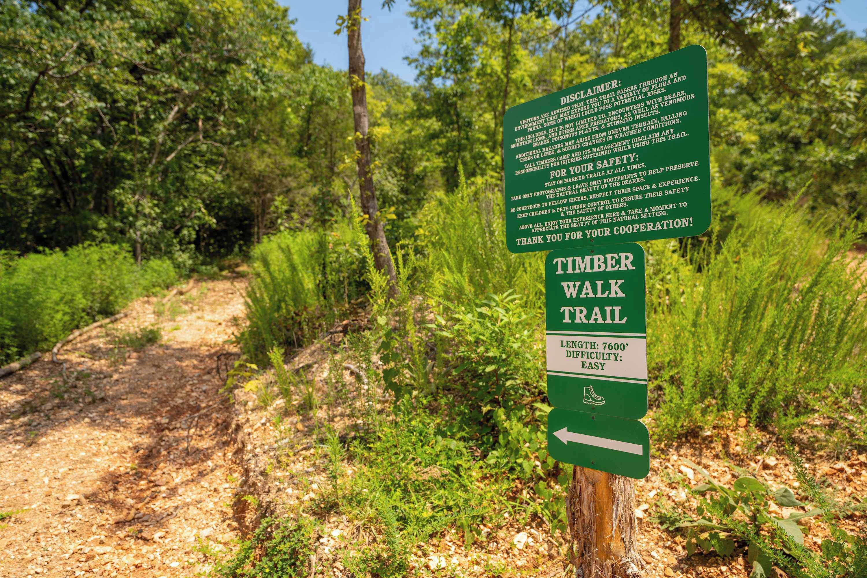 Un panneau indiquant le début du sentier de randonnée de Timber Walk, précisant qu’il s’agit d’un sentier de 7 600 pieds de long et de difficulté facile.