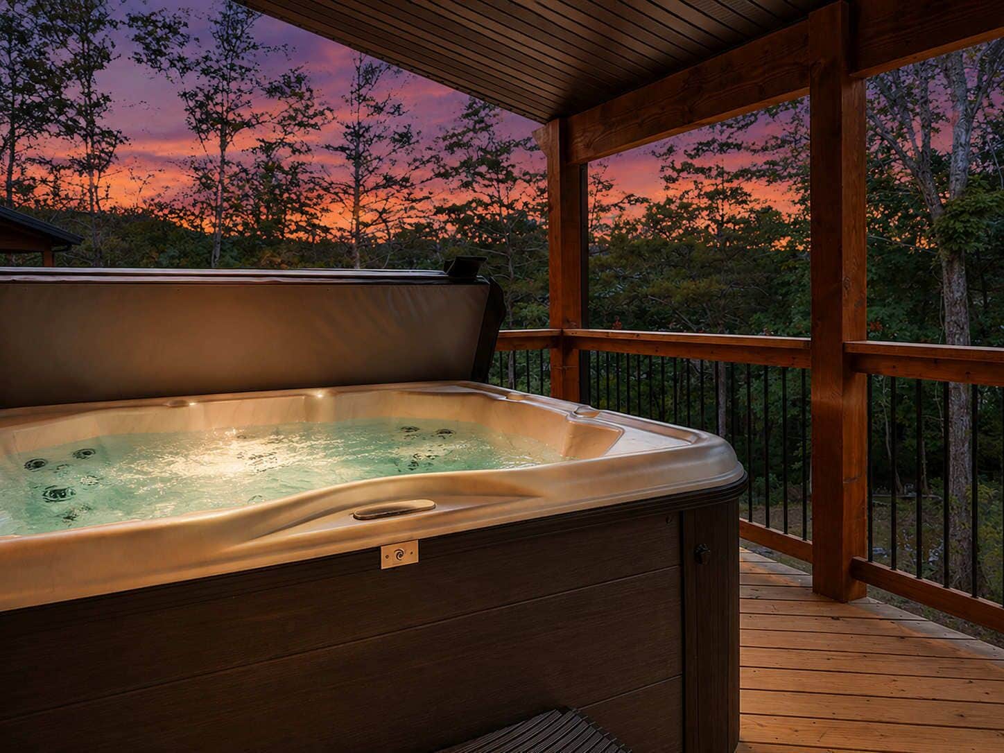 Een hottub op een houten terras met uitzicht op bomen en een zonsondergang.