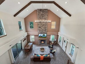 A spacious living area with a fireplace, a dining table, and multiple seating options.