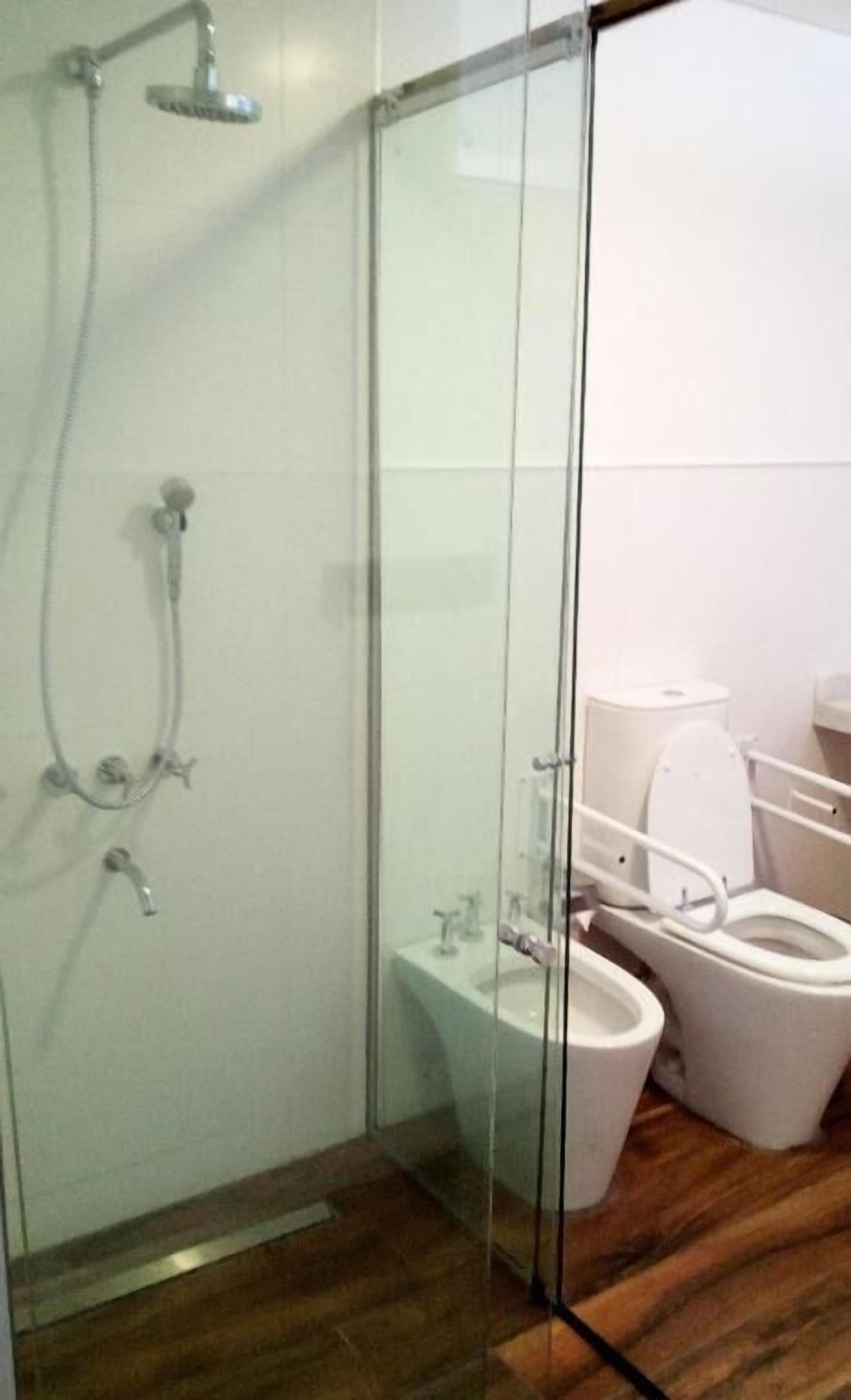 Un baño con cabina de ducha de vidrio, inodoro y bidé.
