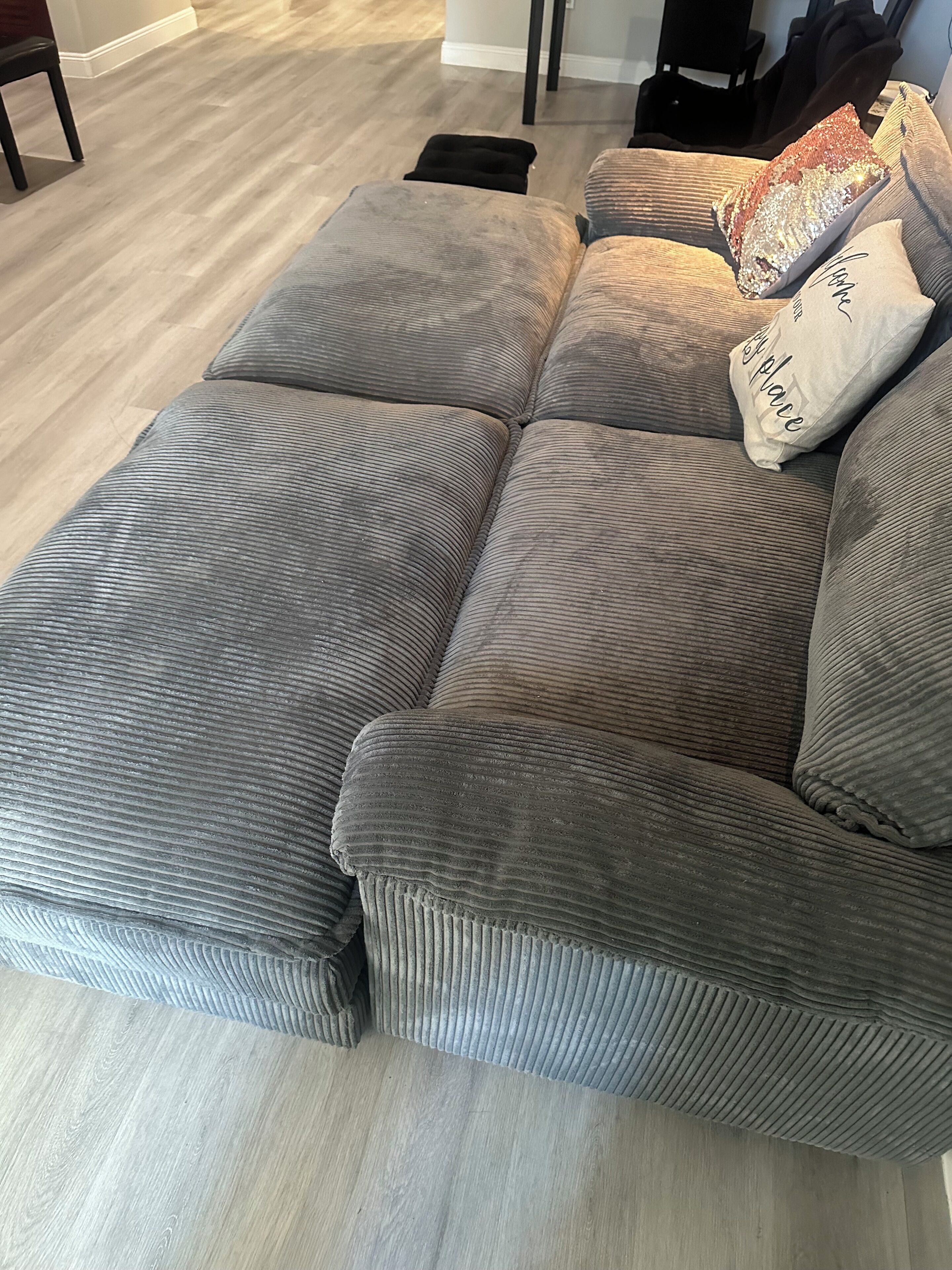 A sectional sofa with a textured fabric and a cushion.