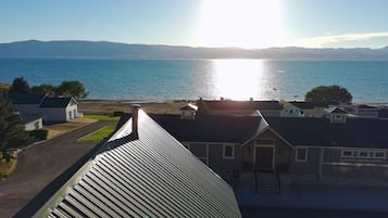 Un barrio residencial con casas, una calle y una masa de agua al fondo.