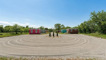 A circular driveway leading to a row of small, colorful cabins.