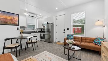 Un appartement moderne comprenant une cuisine, un coin repas et un salon.
