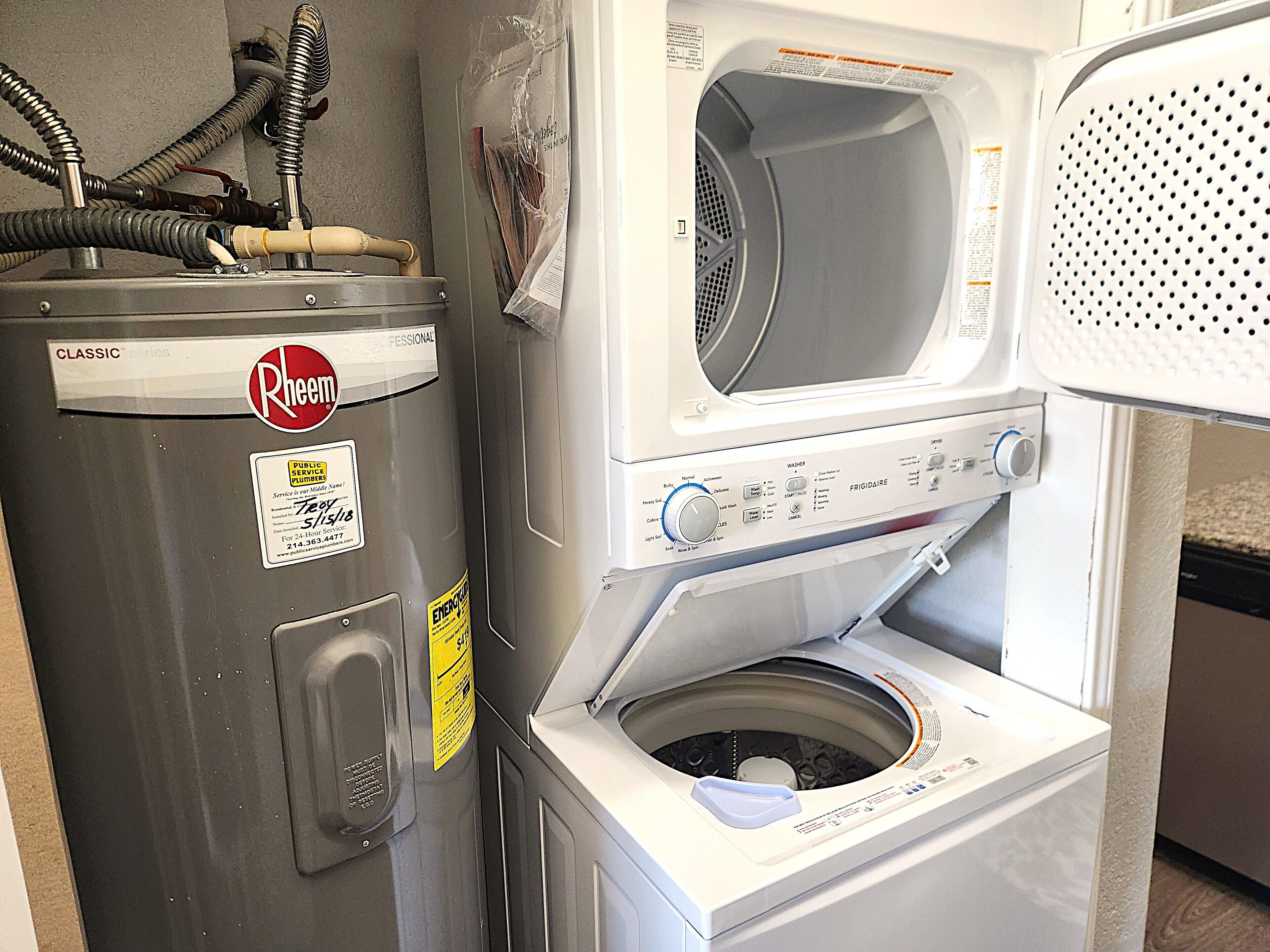A front-loading washing machine with a control panel, a dryer, and a water heater.