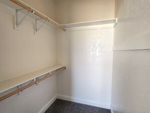 Una habitación con techo de viga de madera, una puerta blanca y suelo alfombrado.