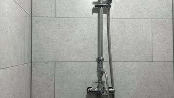 Een douche met een handdouche en een douchekop aan de muur.