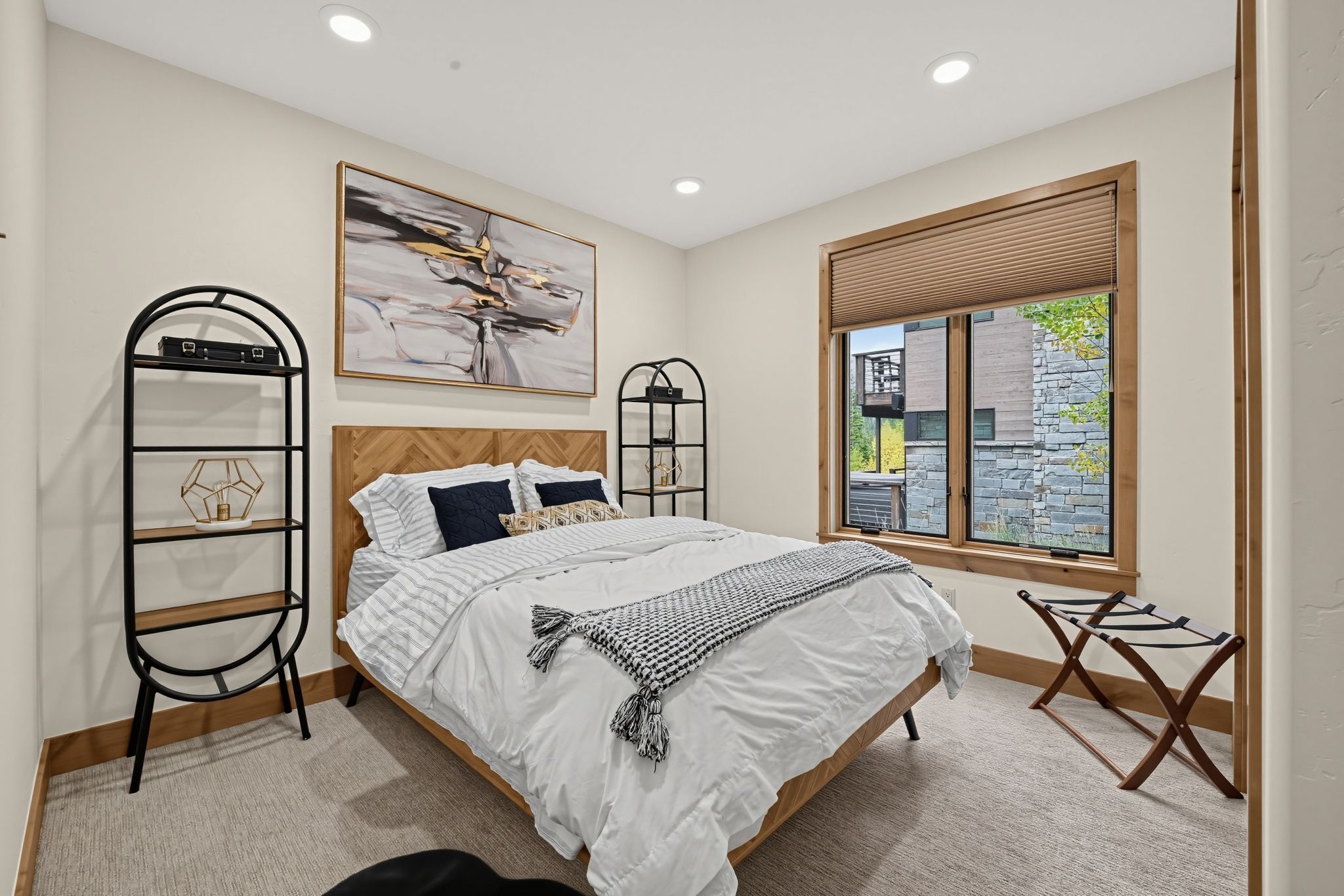 Een slaapkamer met een bed, een raam met uitzicht en een schilderij aan de muur.