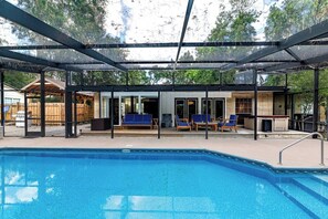 A swimming pool with lounge chairs and a covered patio area. - Gator Pool Home - Close to UF (Gainesville)