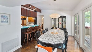 Un comedor con una mesa grande, sillas y una lámpara colgante.