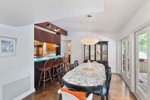 A dining area with a large table, chairs, and a hanging light fixture. - Gator Pool Home - Close to UF (Gainesville)
