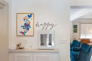 Ein Küchenbereich mit Wasserspender, einem gerahmten Kunstwerk und einem Schild mit der Aufschrift 'happy'.