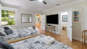 A bedroom with two beds, a TV, and a ceiling fan. - Quaint and Quiet near UF! (Gainesville)