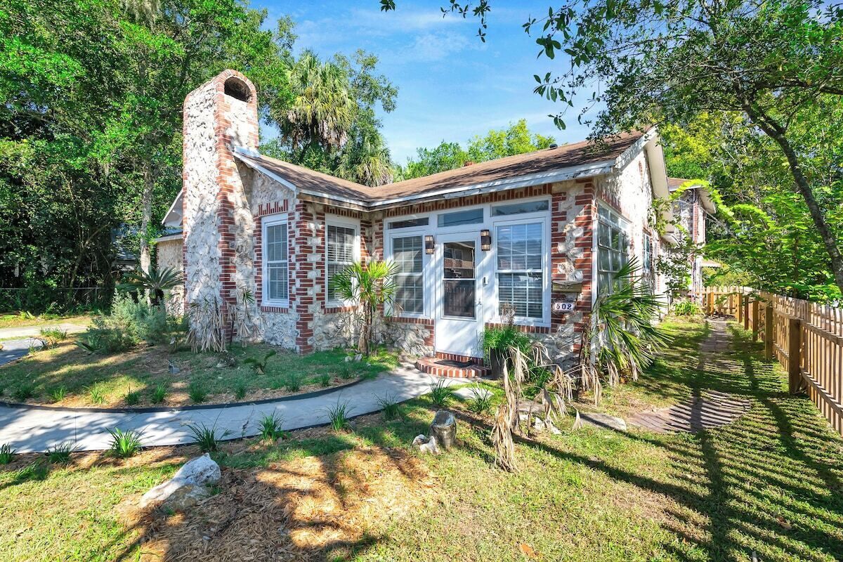 A house with a brick exterior, a chimney, and a front porch.