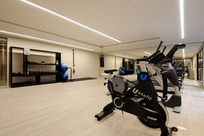 A gym with exercise equipment, a mirrored wall, and a wooden floor. - Homey 3BR Apt near Parque México|Pool & Gym (Ciudad de México)
