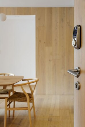 Una porta de fusta amb un tancament electrònic de codi i un manilla de palanca.