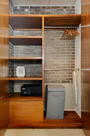 Ein begehbarer Kleiderschrank mit Holzböden, einer Kleiderstange und einem kleinen Stauraum.