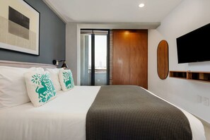 Ein Hotelzimmer mit einem Bett, einem Fernseher, einem Fenster und einer Tür.