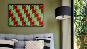 Ein modernes Wohnzimmer mit einem grauen Sofa, einer schwarzen Stehlampe und einem gewebten Korb.