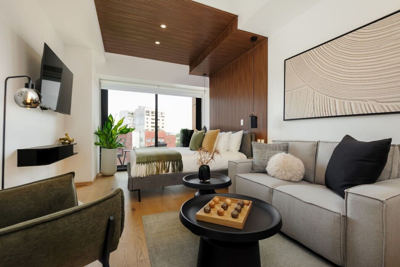 Ein modernes Wohnzimmer mit einer Couch, einem Couchtisch und einem an der Wand befestigten Fernseher.