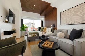 Ein modernes Wohnzimmer mit einer Couch, einem Couchtisch und einem an der Wand befestigten Fernseher.
