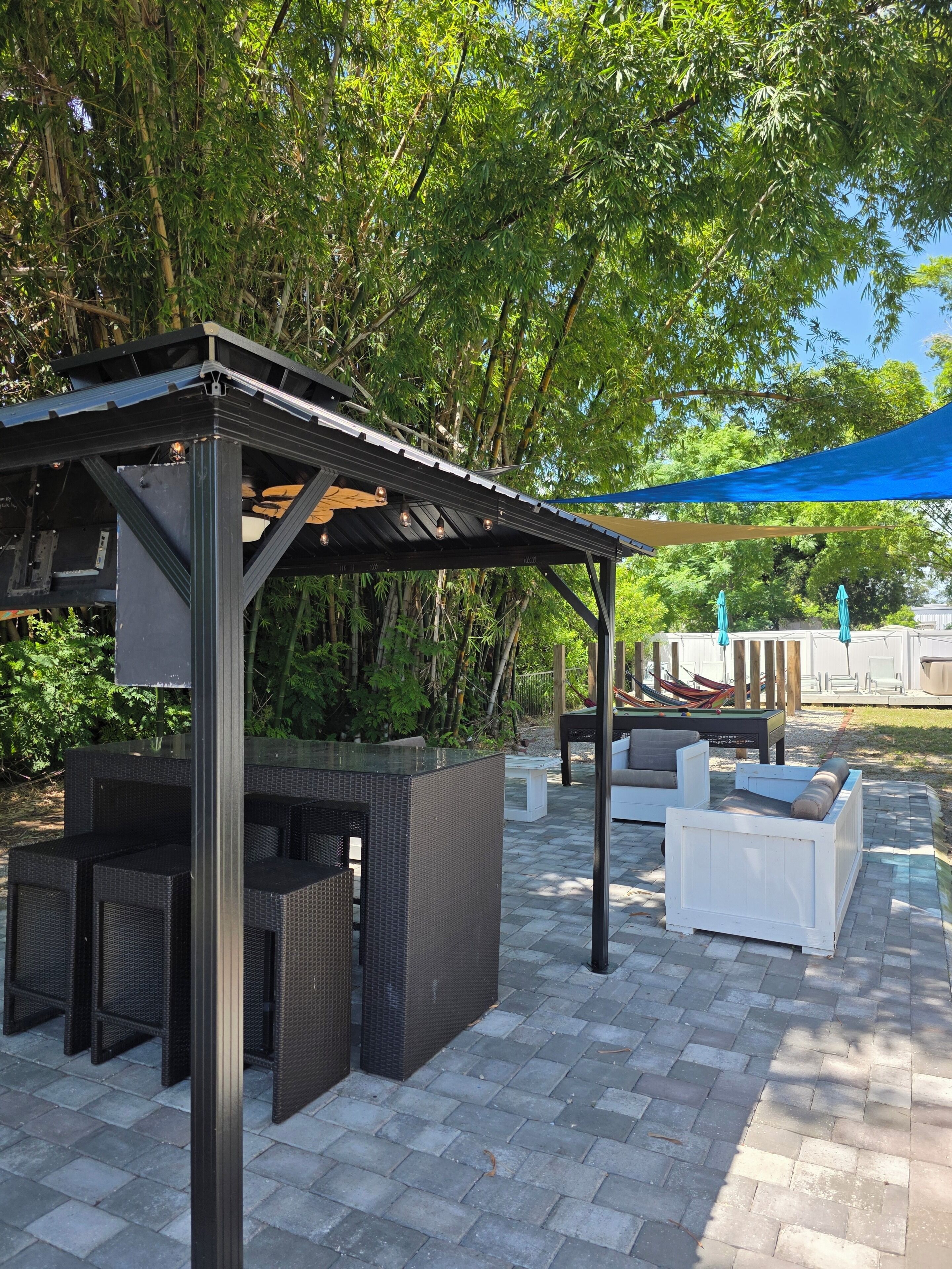 Ein Außenbereich mit Terrasse, Pergola, Sitzgelegenheiten und einem Billardtisch.