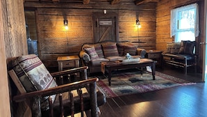 A log cabin interior with a sofa, armchair, and a small table. - Your Home Away From Home. Spacious 6-Bedroom Frewsburg Retreat room for everyone (Frewsburg)