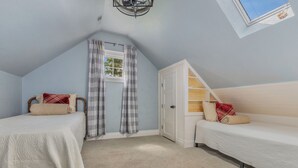 A bedroom with two single beds, a window with curtains, a ceiling fan, and a skylight. - Luxury Retreat, Near Downtown Asheville, Pool, Dog-Friendly, 6BR/5BA, Spacious (Fletcher)