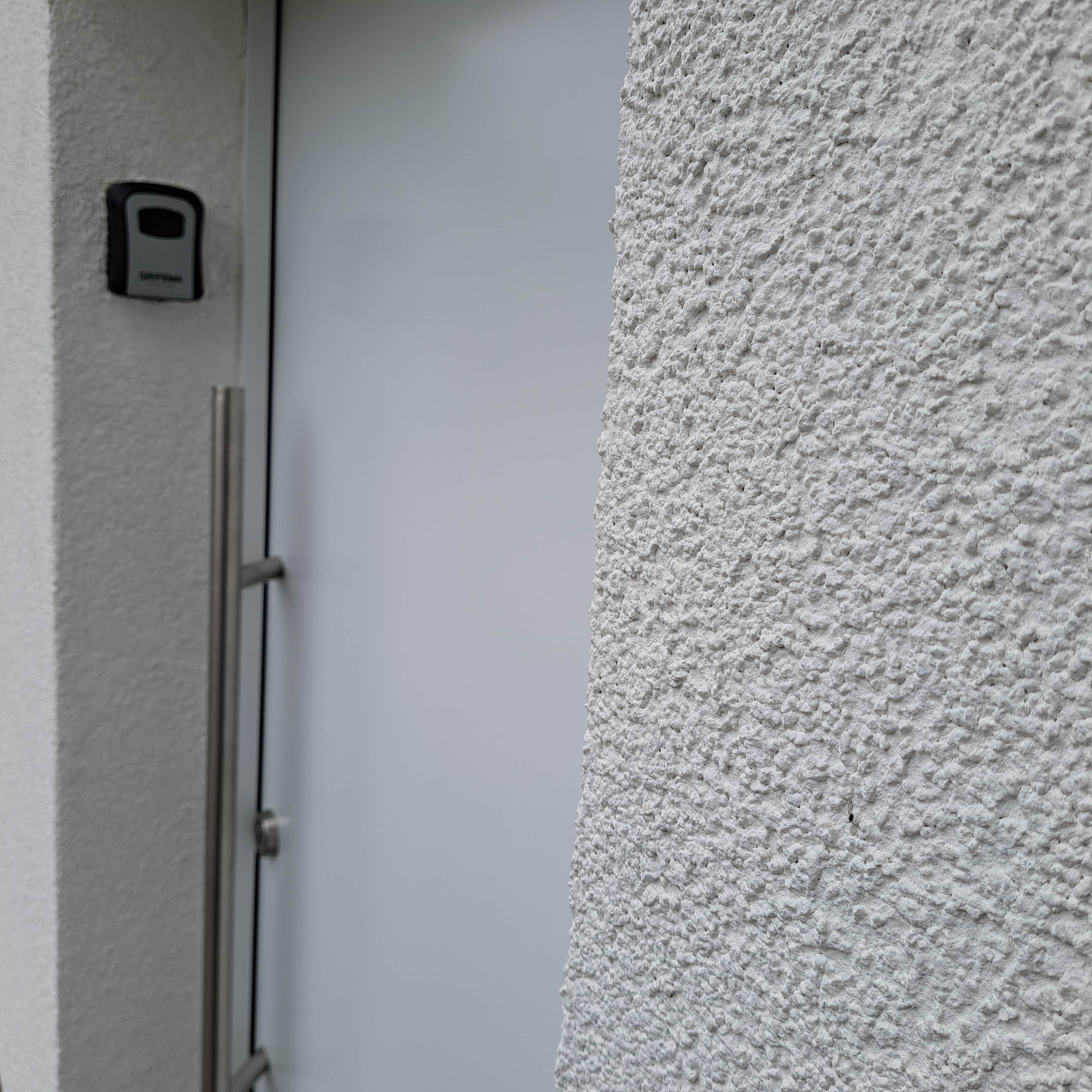 Una parete strutturata con una porta e un dispositivo di sicurezza.