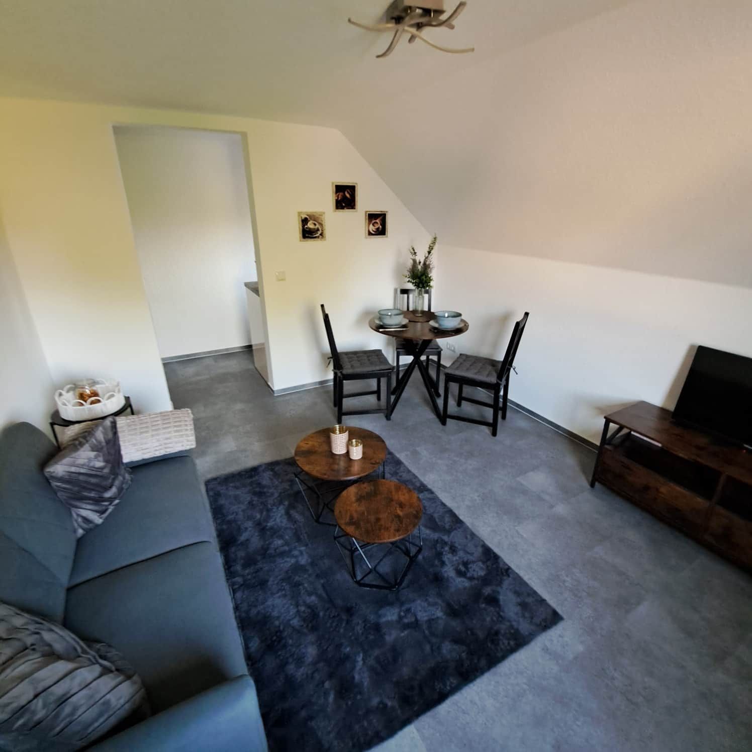 Ein stilvolles Wohnzimmer mit Sofa, Couchtisch und TV-Schrank.