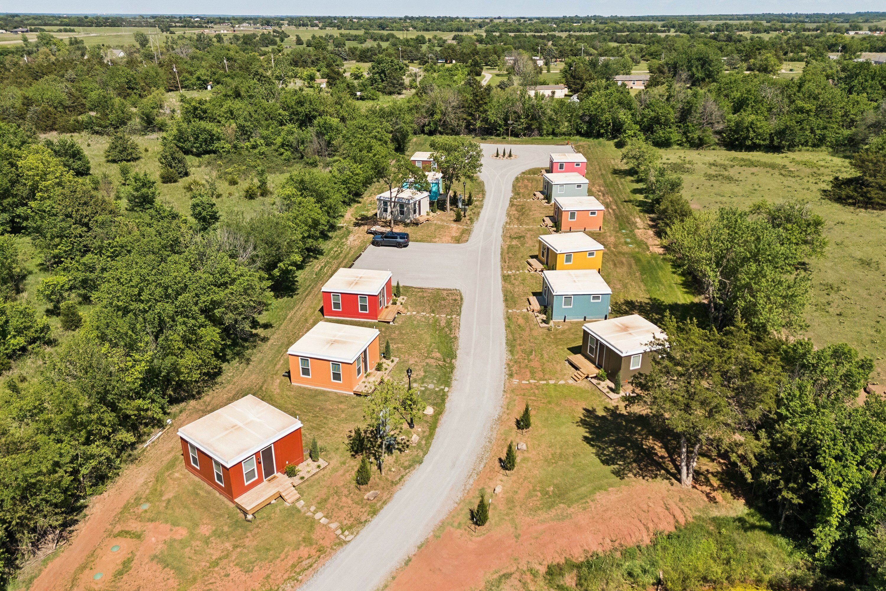 Un barrio residencial con una calle principal y varias casas coloridas.