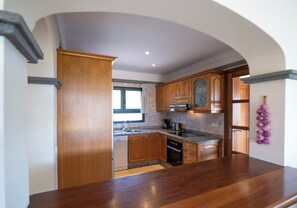 A kitchen with wooden cabinets, a granite countertop, a built-in oven, and a window with a view. - 3 bedroom villa on a sizeable plot, close to Playa Blanca's lighthouse and the amenities of Faro Par (Playa Blanca)
