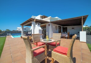 A patio with wicker furniture and a pool. - 3 bedroom villa on a sizeable plot, close to Playa Blanca's lighthouse and the amenities of Faro Par (Playa Blanca)