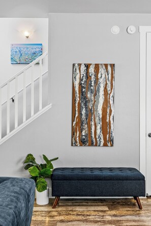A modern interior with a staircase, a bench, a potted plant, and a wall with abstract art. - 2 Suite to be good! Escape to the Mountains! (Flagstaff)