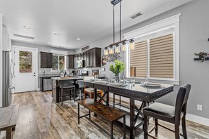 A modern kitchen with a central island, dark cabinetry, and a large window with blinds. - 2 Suite to be good! Escape to the Mountains! (Flagstaff)