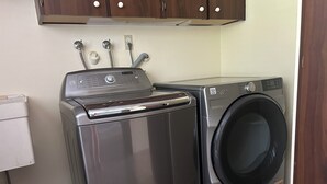 Un espacio práctico para la lavandería con lavadora de carga frontal y secadora superpuesta.