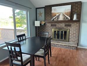 A dining area with a brick fireplace, a view of a pier, and a starfish decoration. - Waterfront Retreat on Hammersley Inlet (Shelton)