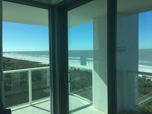 Uma varanda com vista para a praia e o oceano.