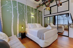 Ein Schlafzimmer mit Bett, Nachttisch und einem Spiegel, der den Raum wiedergibt.