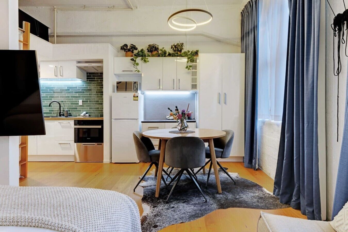 A modern apartment with a dining area, kitchen, and living space.