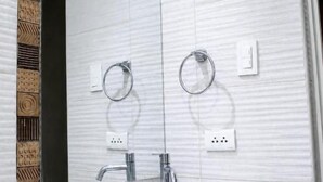 Un bany amb un rentapans blanc, un mirall i un dispensador de tovalloles.
