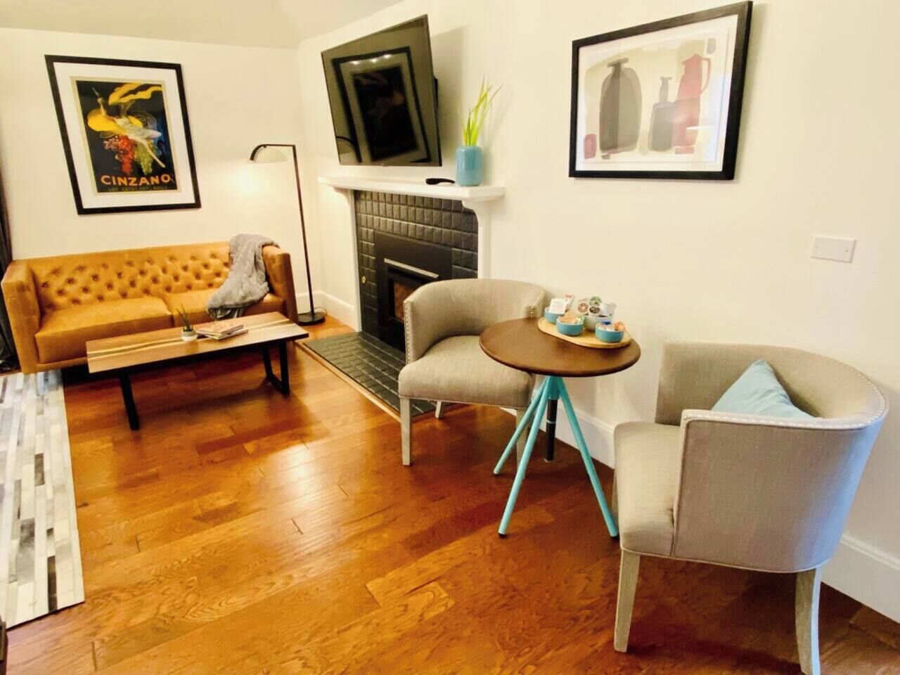 A living room with a sofa, a round table, and a fireplace.