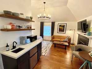 A compact living space with a kitchenette, a sofa, a dining area, and a fireplace. - A Private Guesthouse Studio - The Owl (Napa)