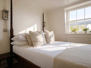 A bedroom with a four-poster bed, a window with plants, and a radiator. - South Ken Rooftop Loft, Treetop Views, Hyde Park (London)