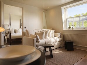 Een moderne woonkamer met een bank, een klein tafeltje en een raam met uitzicht.