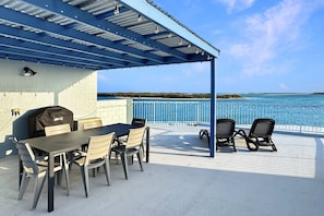 An outdoor patio with a table and chairs, a grill, and a view of the ocean. - Passage Panorama - 3BD Seaview Retreat (Caloundra Region)
