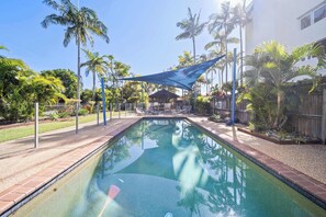 A rectangular swimming pool with a tiled edge, surrounded by a gravel area and a wooden fence. - Passage Panorama - 3BD Seaview Retreat (Caloundra Region)