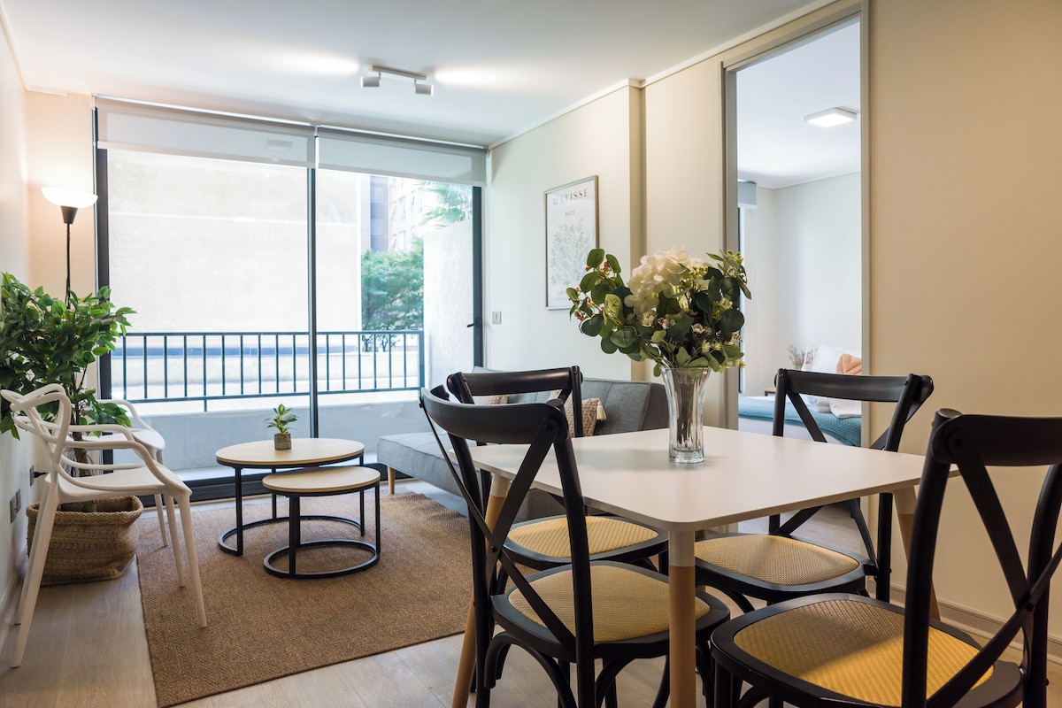 Ein Hotelzimmer mit Essbereich, ausgestattet mit einem Tisch, Stühlen und einer Vase mit Blumen.