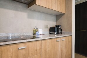 Een keuken met houten kastjes, een granieten aanrecht, een koffiezetapparaat en een waterkoker.